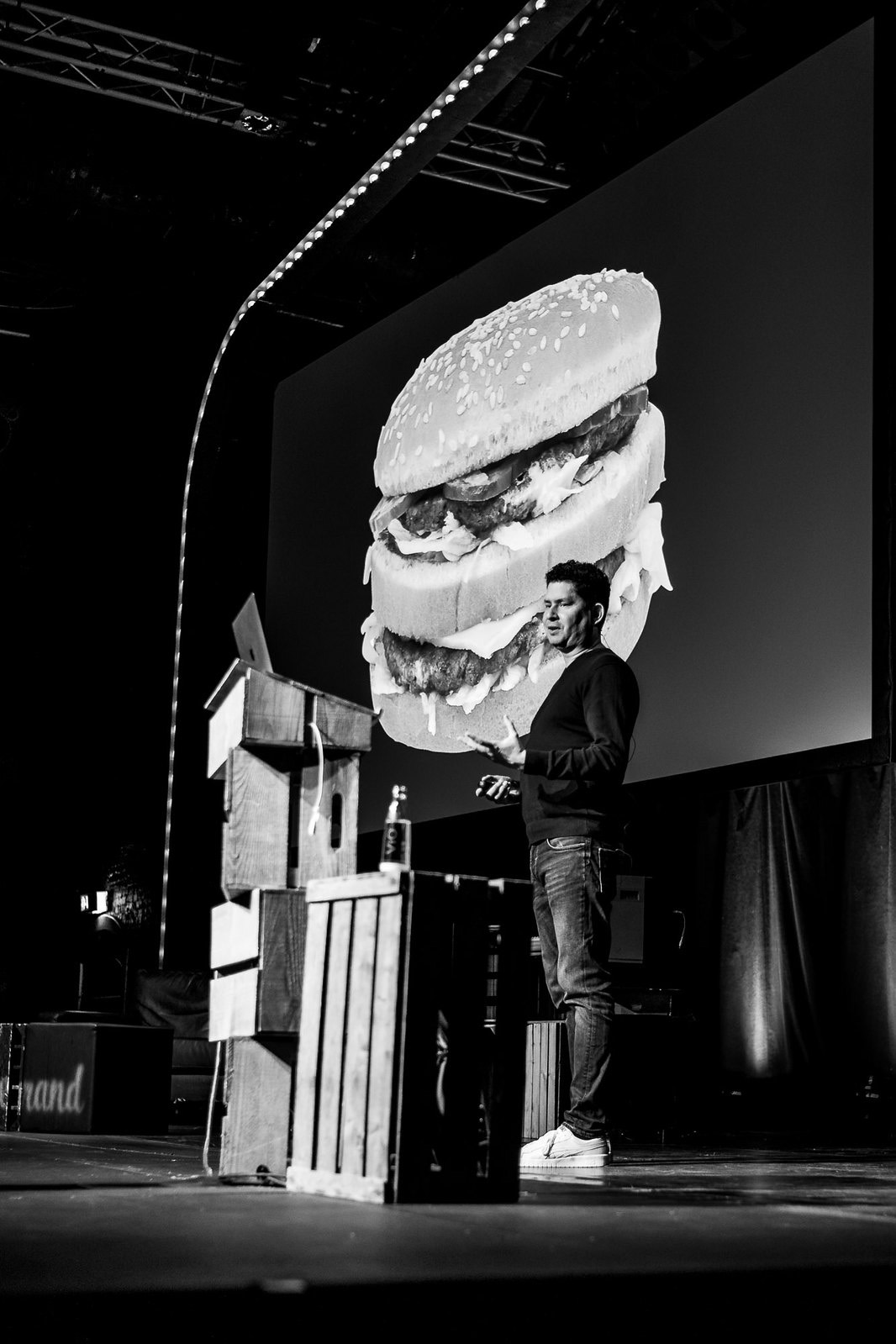 Voici une photographie de Stephen Hay, au Beyond Tellerrand présentant son slide burger pour parler des menus burgers